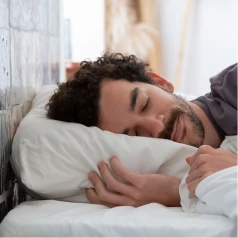 Adult male having a restful sleep after taking sleep supports to help him doze peacefully